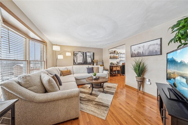 living room featuring bar area and hardwood / wood-style floors