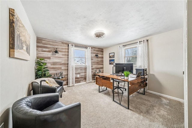 office area with light carpet, wooden walls, and a wealth of natural light