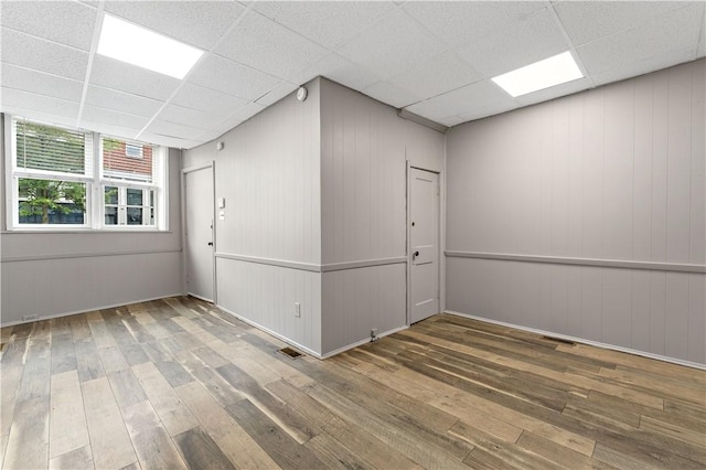 unfurnished room featuring hardwood / wood-style floors and a drop ceiling