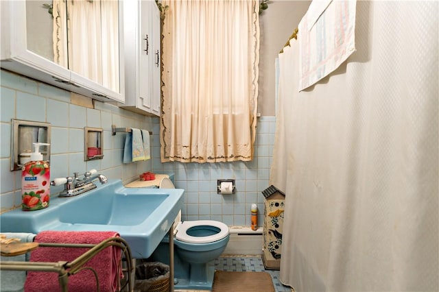 bathroom with tile patterned flooring, toilet, curtained shower, and sink