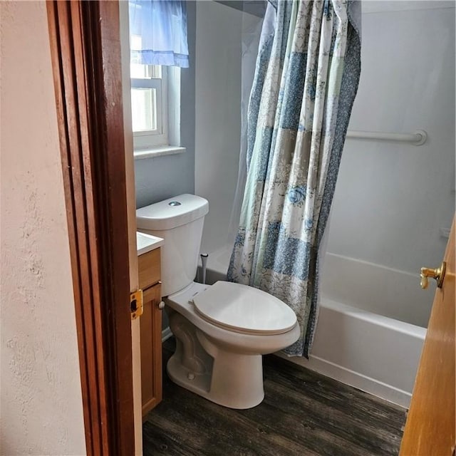 full bathroom featuring hardwood / wood-style flooring, vanity, toilet, and shower / bathtub combination with curtain