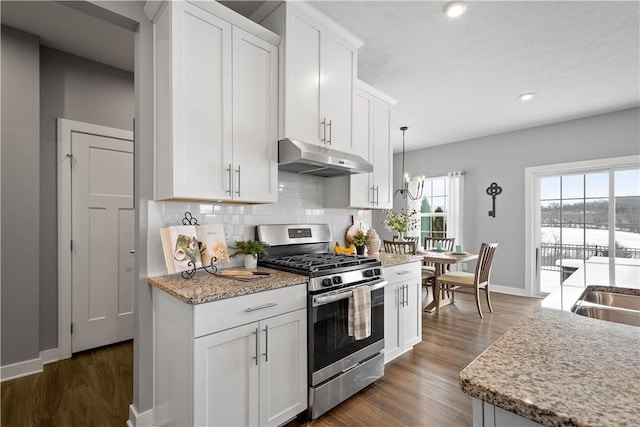 kitchen with hanging light fixtures, stainless steel gas range oven, dark hardwood / wood-style flooring, decorative backsplash, and white cabinetry