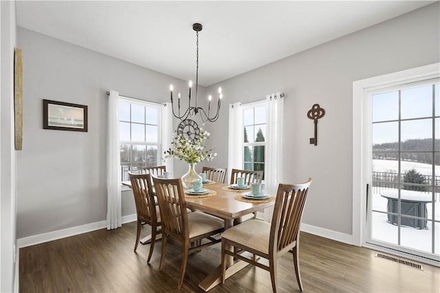 dining room featuring a notable chandelier and dark wood-type flooring