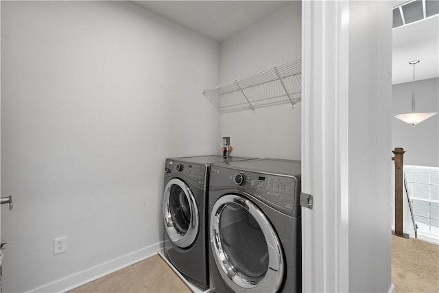 laundry area with washer and dryer and light tile patterned flooring