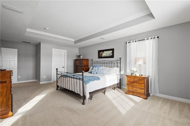 carpeted bedroom with a tray ceiling