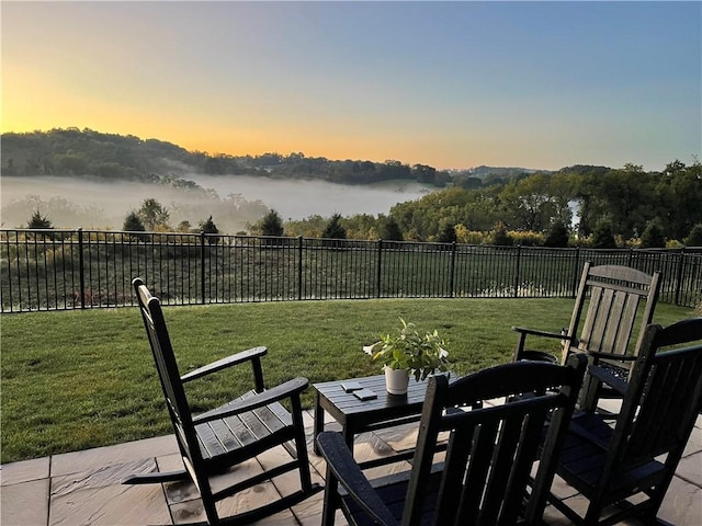 yard at dusk featuring a patio