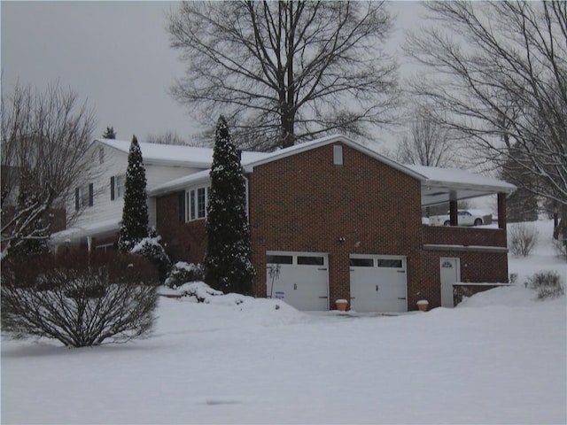 snow covered property with a garage