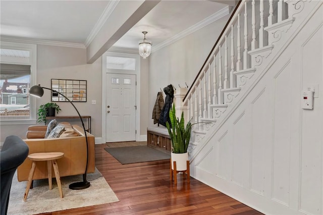 foyer entrance with hardwood / wood-style flooring, an inviting chandelier, and crown molding