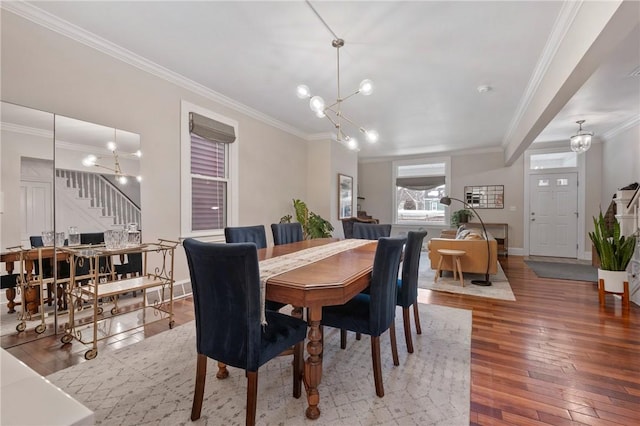 dining room with crown molding, wood-type flooring, and a notable chandelier