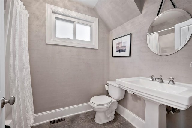 bathroom featuring lofted ceiling, sink, tile patterned flooring, a shower with shower curtain, and toilet