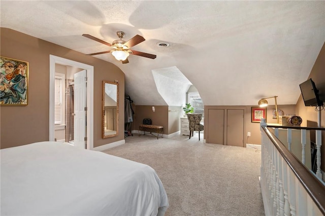 carpeted bedroom with a textured ceiling, vaulted ceiling, and ceiling fan