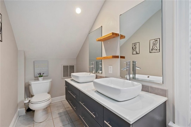 bathroom with tile patterned flooring, vanity, toilet, and lofted ceiling