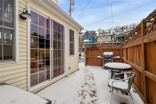 snow covered patio featuring a grill