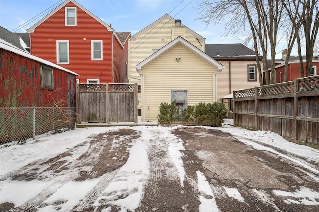 view of snow covered back of property