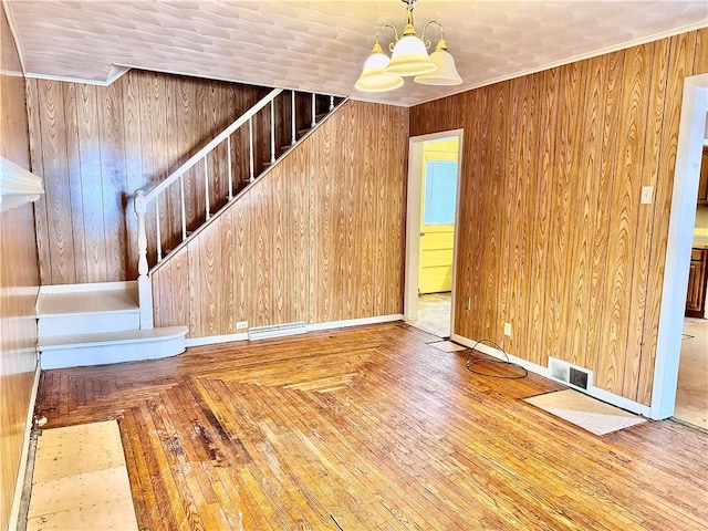 interior space with crown molding, wooden walls, and an inviting chandelier