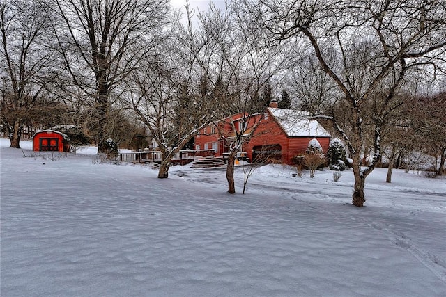 snowy yard featuring a storage unit