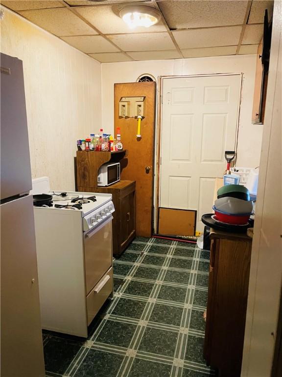 kitchen with a drop ceiling and white appliances