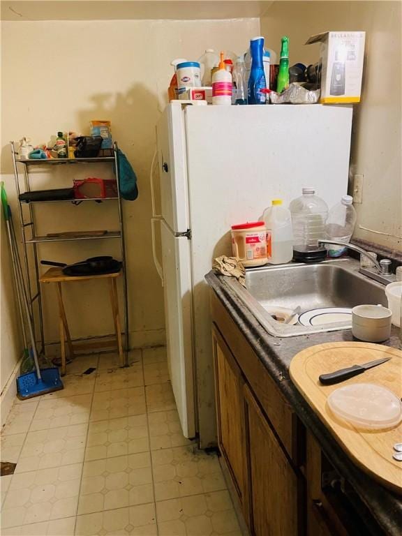 kitchen featuring white refrigerator and sink