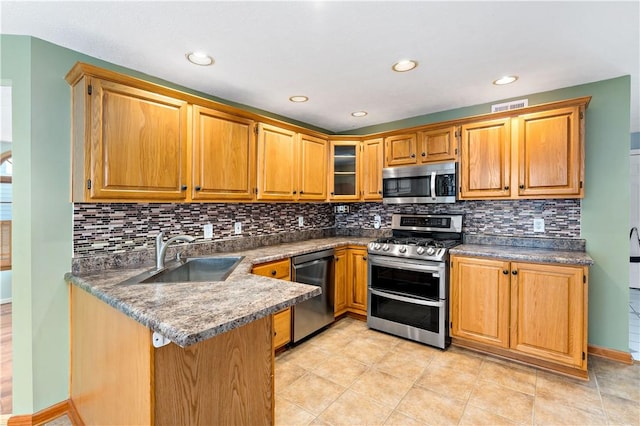 kitchen featuring sink, stainless steel appliances, backsplash, kitchen peninsula, and light tile patterned floors