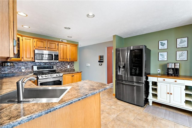 kitchen featuring backsplash, light tile patterned flooring, sink, and appliances with stainless steel finishes