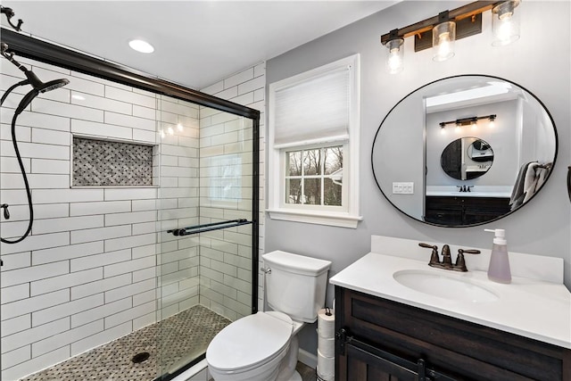 bathroom with vanity, toilet, and a shower with shower door