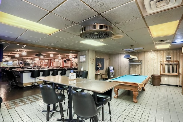 rec room featuring wooden walls, light tile patterned floors, pool table, and indoor bar