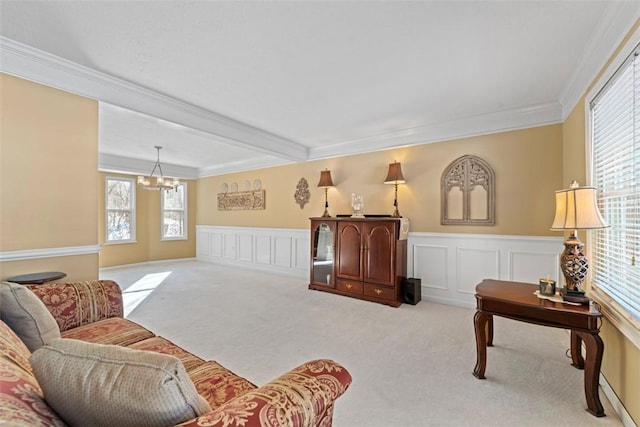 carpeted living room featuring beam ceiling, crown molding, plenty of natural light, and a chandelier