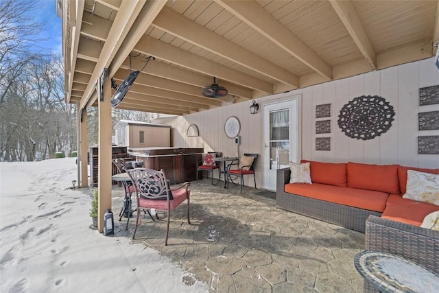 snow covered patio featuring an outdoor hangout area and a hot tub