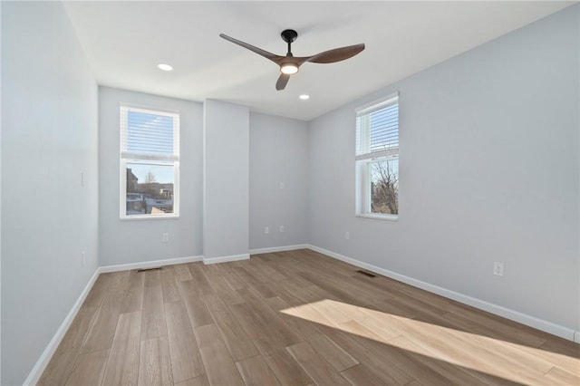 unfurnished room with light hardwood / wood-style flooring, a wealth of natural light, and ceiling fan