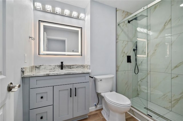 bathroom featuring hardwood / wood-style floors, vanity, toilet, and a shower with door