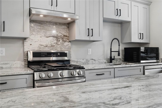 kitchen featuring light stone countertops, stainless steel appliances, tasteful backsplash, and sink