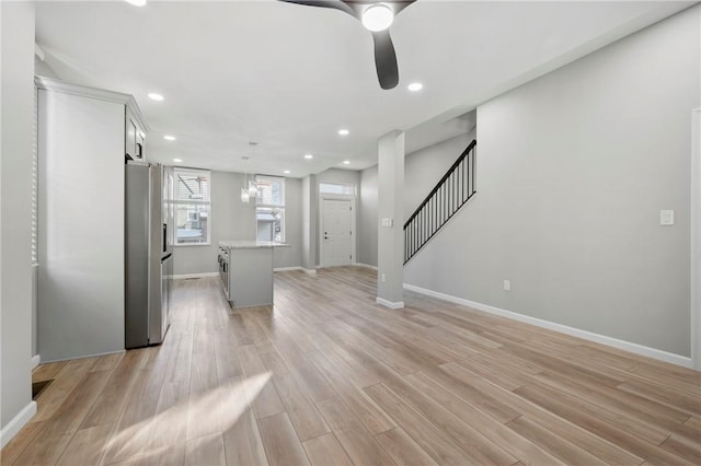 unfurnished living room with light wood-type flooring and ceiling fan