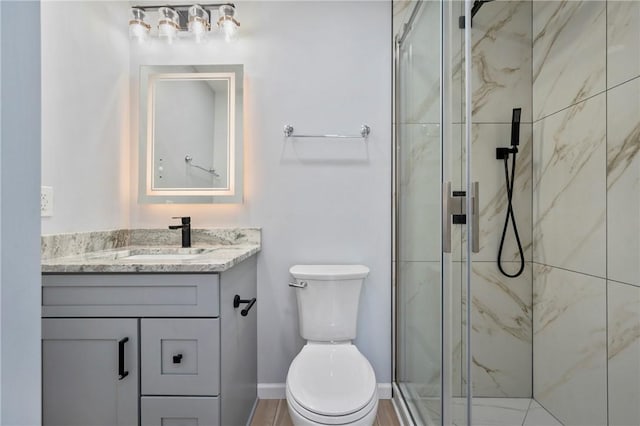 bathroom featuring vanity, an enclosed shower, and toilet