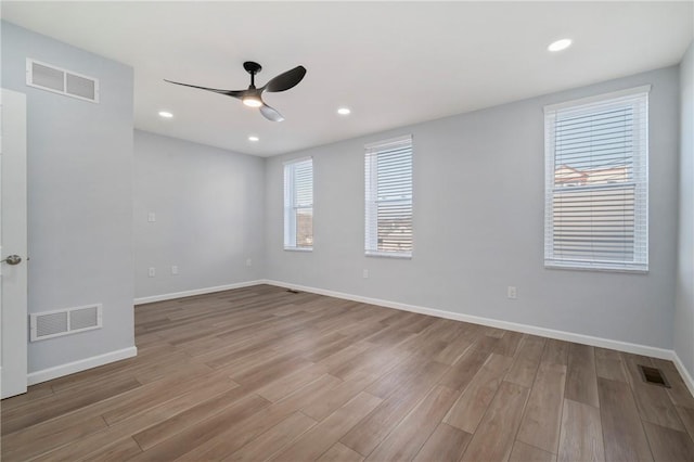 spare room with ceiling fan and light wood-type flooring