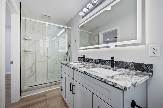 bathroom with vanity and a shower with door