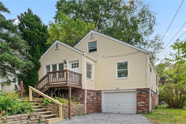 rear view of property featuring a garage and a deck