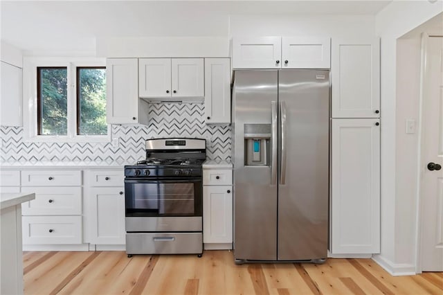 kitchen featuring appliances with stainless steel finishes, light hardwood / wood-style flooring, white cabinetry, and tasteful backsplash