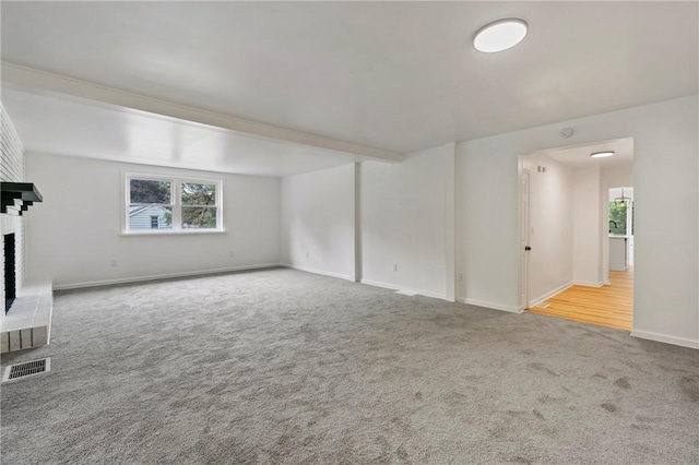 unfurnished living room featuring a fireplace, carpet floors, and plenty of natural light