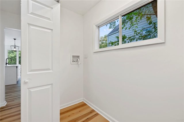 laundry room with sink, washer hookup, and hardwood / wood-style flooring