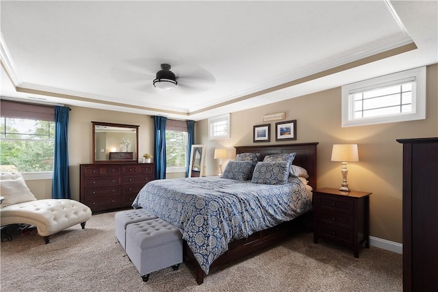 bedroom featuring a raised ceiling, ceiling fan, crown molding, and light colored carpet