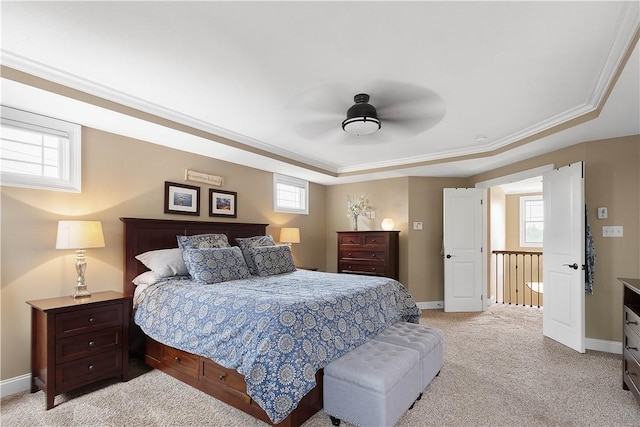 bedroom with multiple windows, a raised ceiling, ceiling fan, and ornamental molding