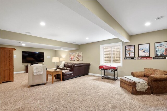 carpeted living room with beamed ceiling