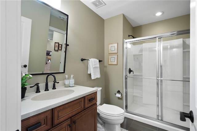 bathroom with tile patterned flooring, vanity, toilet, and walk in shower