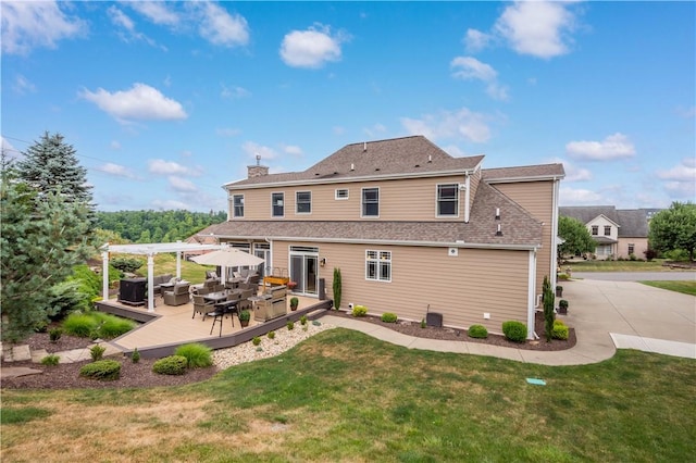 back of property with a pergola and a lawn