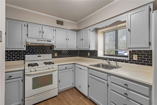 kitchen featuring backsplash, light wood-type flooring, white appliances, and sink