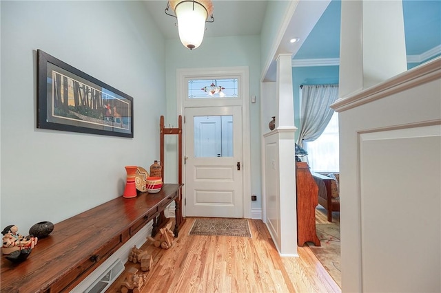 doorway to outside featuring light hardwood / wood-style flooring and crown molding