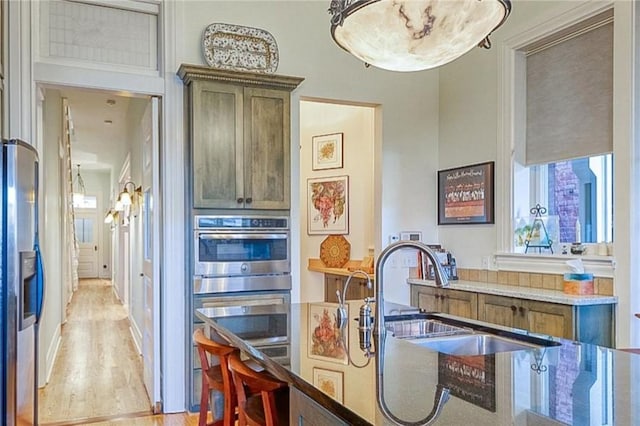 kitchen with light wood-type flooring, sink, and appliances with stainless steel finishes