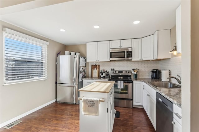 kitchen with white cabinetry, sink, stainless steel appliances, dark hardwood / wood-style floors, and butcher block countertops