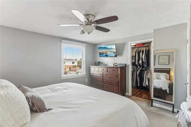 bedroom featuring light colored carpet, a closet, and ceiling fan