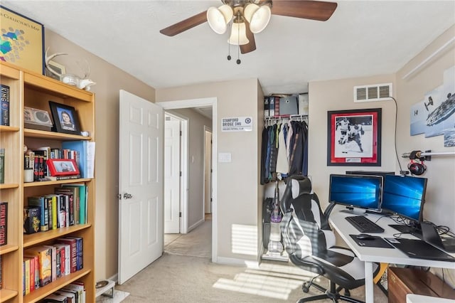 carpeted office space with ceiling fan